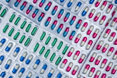 Full frame of colorful capsule pills in blister pack arranged with beautiful pattern. Pharmaceutical packaging. Medicine for infections disease. Antibiotic drug use with reasonable. Drug resistance. clipart