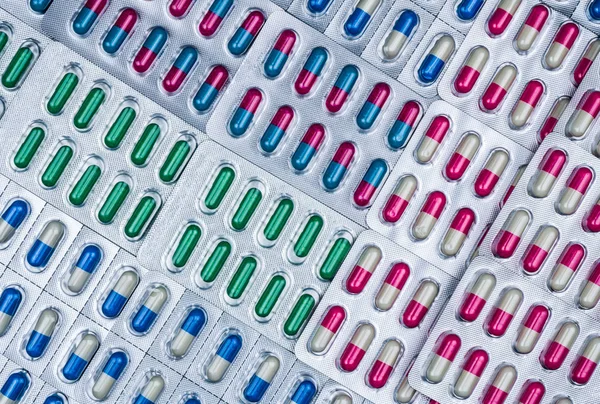 Marco completo de píldoras de cápsulas de colores en blister arreglado con hermoso patrón. Embalaje farmacéutico. Medicina para infecciones enfermedad. Uso de medicamentos antibióticos con razonable. Resistencia a medicamentos . — Foto de Stock