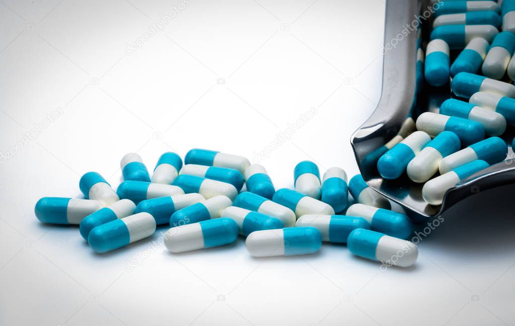 Blue and white capsules pills and drug tray on white background with copy space for text. Global healthcare concept. Antibiotics drug resistance concept. Antimicrobial capsule pills.