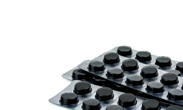 Compresse a carbone attivo in blister isolate su sfondo bianco con spazio per la copia del testo. Pillole rotonde nere per avvelenamento da trattamento da prendere overdose di droga — Foto Stock