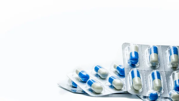 Pile di capsule blu, bianche in blister isolato su sfondo bianco con spazio per la copia. Concetto sanitario globale — Foto Stock