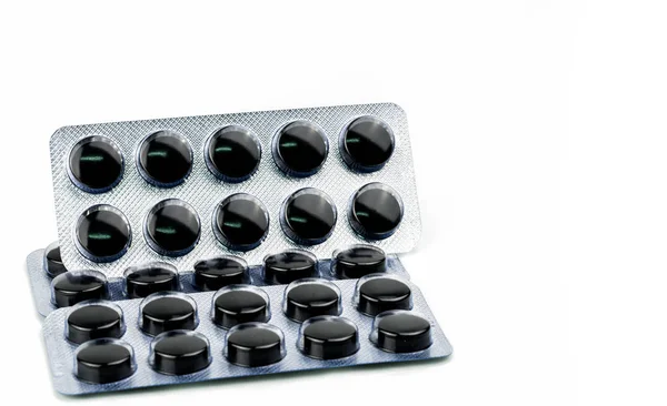 Pastillas de carbón activado en blíster aisladas sobre fondo blanco con espacio de copia para texto. Pastillas redondas negras para el envenenamiento por tratamiento por sobredosis de drogas — Foto de Stock