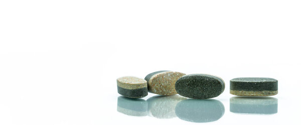 Основные витамины и минералы добавки двойной слой таблетки таблетки изолированы на белом фоне. Мультивитамины плюс рейши грибы, пшеничная трава, белый чай и органическая спирулина. Питательные вещества
.