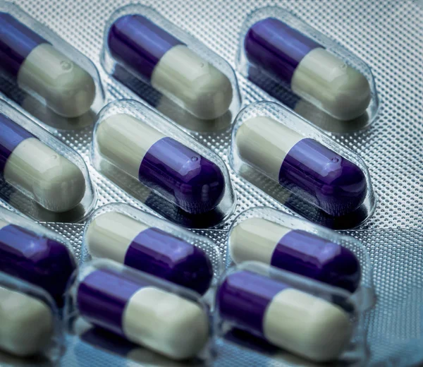 Fluconazole : médicament antifongique. Image plein cadre de violet, capsules blanches pilules. Concept de soins de santé. Les pilules médicinales peuvent endommager le foie. Industrie pharmaceutique contexte . — Photo