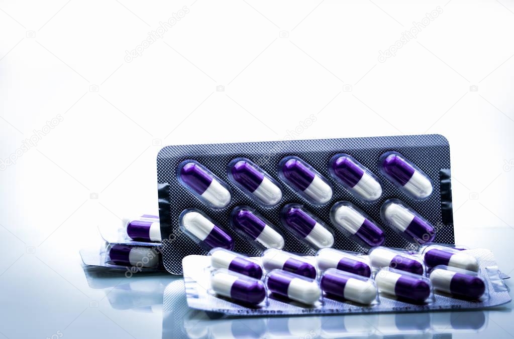 Fluconazole : Antifungal medicine. Heap of pills in blister packs on white background. Healthcare concept. Medicine pills can cause liver damage. Pharmaceutical industry background.