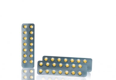 Small round light yellow enteric-coated tablet pills in blister pack isolated on white background with copy space. Medicine for treatment gastric ulcer (stomach ulcer) or GERD. clipart