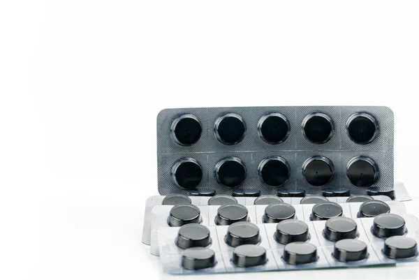 Aktivní uhlí tablet v blistru izolovaných na bílém pozadí s kopií prostoru pro text pilulky. Černé kulaté tablety pro léčbu otravy z se předávkování drogami — Stock fotografie
