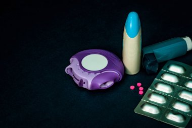Astım inhaler, accuhaler ve Anti Alerjik hap tedavisi astım için kümesi. Astım denetleyicisi, kesici ekipman kopya alanı ile karanlık tabloda. Bronchodilator ve steroid şiddetli astım ilacı.