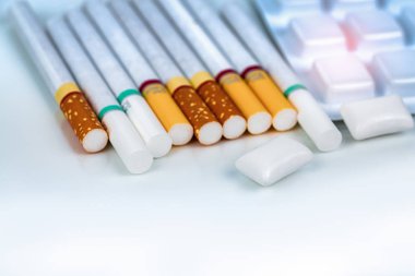 Nikotin sakız sigara yığını yakınındaki Vakumlu Ambalaj içinde. Tarafından kullanım nikotin sakızı nikotin yoksunluk belirtileri rahatlama için sigarayı bıraktım. Tıp sigarayı verdiğiniz için. Dünya hiçbir tütün gün kavramı.