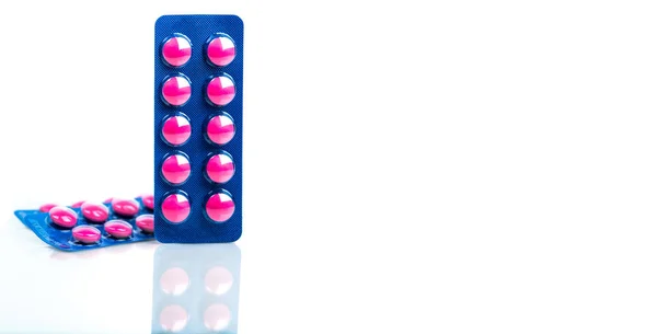 Ibuprofeno en comprimidos de color rosa envase en blíster azul aislado sobre fondo blanco con espacio para copiar. Ibuprofeno para el alivio del dolor, dolor de cabeza, fiebre alta y antiinflamatorio. Pastillas analgésicas . — Foto de Stock