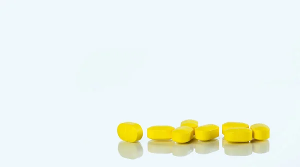Comprimidos amarelos comprimidos isolados em fundo branco com espaço de cópia para texto. Comprimidos de ibuprofeno. Medicina analgésica para dor de cabeça, febre alta e anti-chama. Conceito de indústria farmacêutica . — Fotografia de Stock