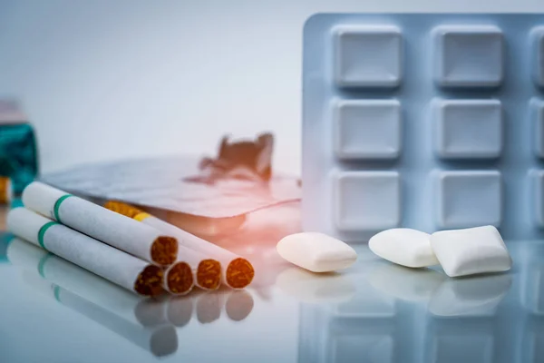 Goma de mascar de nicotina en blister cerca de la pila de cigarrillos. Dejar de fumar o dejar de fumar y el concepto de cáncer de pulmón. 31 de mayo: Día mundial sin tabaco . — Foto de Stock