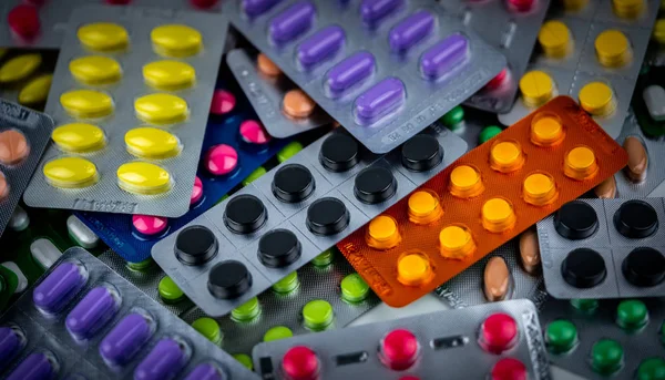 Pile of Colorful tablets pill in blister packaging. Pharmaceutical industry concept. Pharmacy drugstore. Pain killer and drug interaction with charcoal concept. — Stock Photo, Image