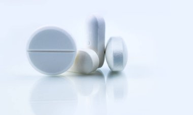 Beyaz arka plan üzerinde izole beyaz yuvarlak ve dikdörtgen şekli tablet hap yığını. İlaç endüstrisi. Eczane veya eczane işareti ve sembolü. Küresel sağlık kavramı. Sağlık ve Farmakoloji.