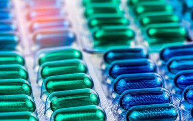 Seçici odak blister pack içinde mavi ve yeşil yumuşak jel kapsül hap üzerinde. Naproksen ve ibuprofen (Nonsteroidal anti-inflamatuar ilaçlar): ağrı kesici ilaç. İlaç Ambalaj Sanayi.