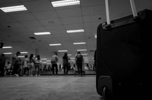 Close-up bagage op wazige mensen die wachten op bagage op transportband bij bagageband in de luchthaventerminal. Passagier verloor bagage tijdens de transitvlucht op het luchthavenconcept. Vakantie reizen. — Stockfoto