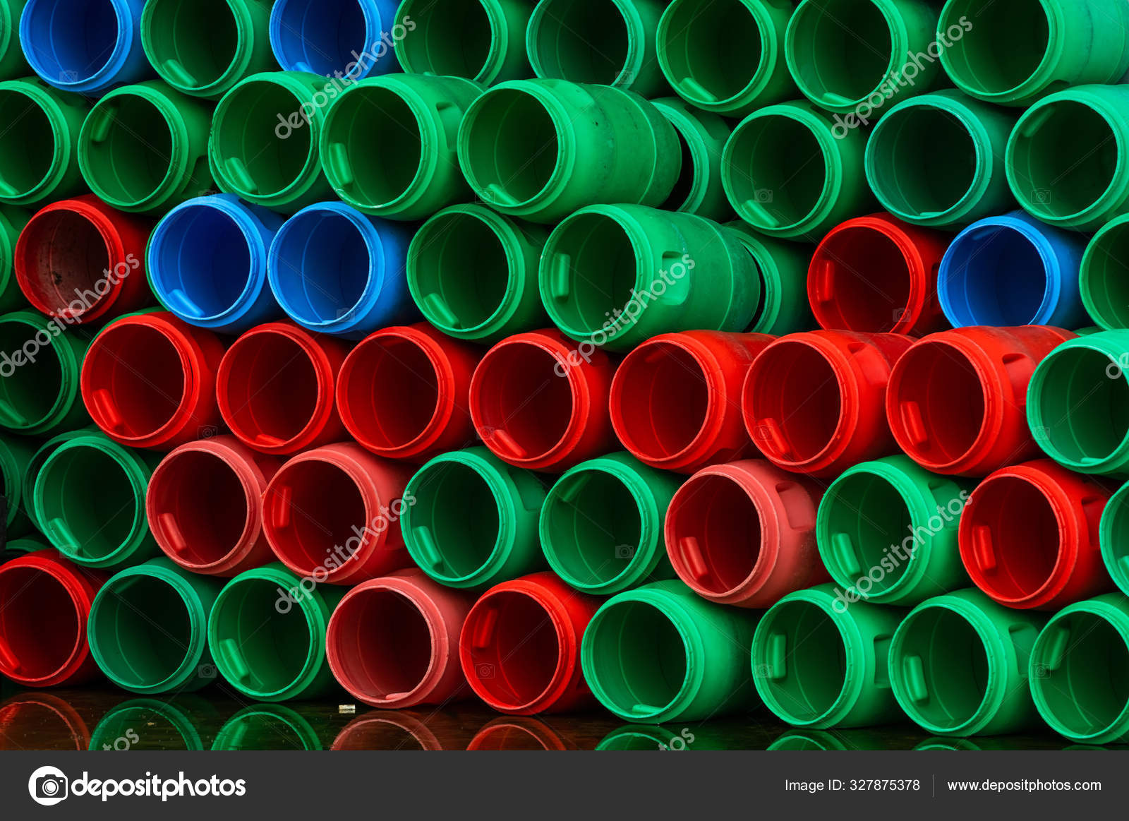 Used plastic barrels. Blue, green, and red plastic drum. Stacked of
