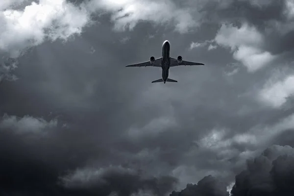 Airplane flying on dark sky and white clouds. Commercial airline with dream destinations concept. Aviation business crisis concept. Failed journey vacation flight. Air transportation. Sad travel.