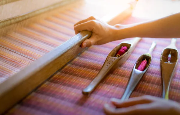El yapımı kumaş dokuma makinesi üzerinde çalışan bir kadın. Tekstil dokuması. Geleneksel el dokuma tezgahlarını pamuk lifleri üzerinde dokumak. Tayland 'da tekstil ya da kumaş üretimi. Asya kültürü.