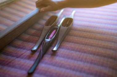 El yapımı kumaş dokuma makinesi üzerinde çalışan bir kadın. Tekstil dokuması. Geleneksel el dokuma tezgahlarını pamuk lifleri üzerinde dokumak. Tayland 'da tekstil ya da kumaş üretimi. Asya kültürü.