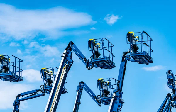 Articulated boom lift. Aerial platform lift. Telescopic boom lift against blue sky. Mobile construction crane for rent and sale. Maintenance and repair hydraulic boom lift service. Crane dealership. — Stock Photo, Image