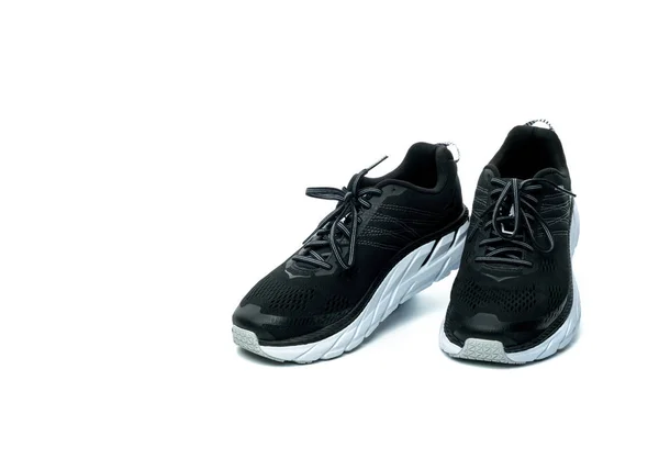 Paar neue Laufschuhe isoliert auf weißem Hintergrund. Schwarze Turnschuhe. Atmungsaktive Sportschuhe aus Stoff mit hoher Gummisohle. Schuhe von Fitnesstrainern. Leichte und bequeme Laufschuhe. — Stockfoto