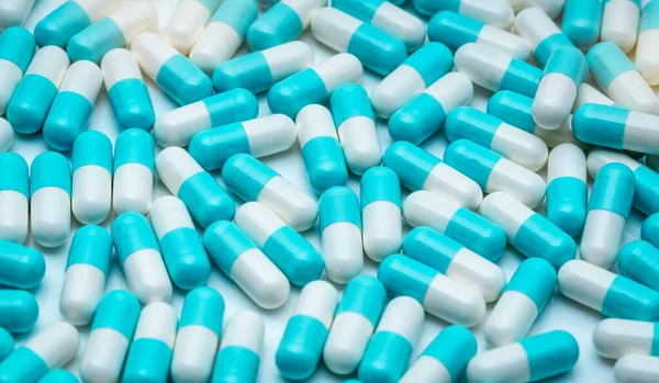 Full frame of antibiotic capsule pills. Blue-white antibiotic capsule pills texture background. Pharmaceutical industry. Healthcare and medicine backdrop. Antibiotic drug resistance and superbug.