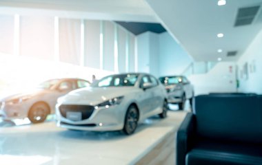 Beyaz araba ve müşterinin ön görüntüsü bulanık. Modern galeride park edilmiş yeni lüks bir araba. Araba galerisi ofisi. Elektrikli araba işi konsepti. Otomobil kiralama. Gösteri salonu iç bina tasarımı.