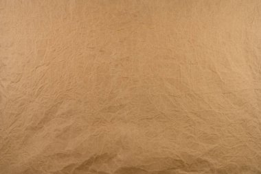 Eski buruşuk kahverengi kağıt doku arka planı. Kaba kahverengi kraft kağıt dokusu. Karton çarşafı geri dönüştür. Kırsal arka plan dizaynı. Kapalı, buruşmuş kağıt torba. Grunge ve buruşuk parşömen. 