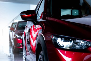 Modern galeriye park edilmiş kırmızı SUV arabası. Yeni ve lüks SUV kompakt araba. Araba galerisi konsepti. Otomotiv endüstrisi. Otomobil kiralama işi. Galeride park etmiş kırmızı parlak arabanın ön manzarası..