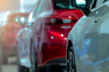 Modern bir galeride park etmiş beyaz ve kırmızı lüks bir araba. Araba galerisi ofisi. Elektrikli araba işi konsepti. Otomobil kiralama. Otomotiv endüstrisinin kriz arka planı. Parlak araba..