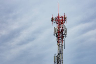 Mavi gökyüzü ve beyaz bulutlu telekomünikasyon kulesi. İşçi telekomünikasyon kulesine 5G ekipman yerleştirdi. İletişim teknolojisi. Telekomünikasyon endüstrisi. Cep telefonu ya da telekom 4G ağı.