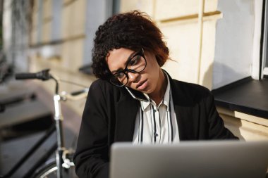Kafeterya masada oturan ve onu laptop çalışma gözlüklü Afro-Amerikan kız portresi