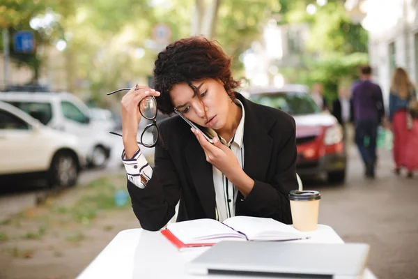 El ve yorgun bir yana onun telefonda konuşurken seyir gözlüklü masada oturan Afro-Amerikan kız portresi