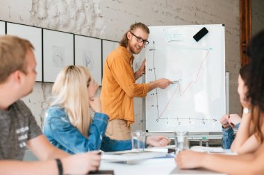 Genç gülümseyen öğretmen kurulu duran ve mutlu öğrenciler diyagramı açıklayan süre seyir