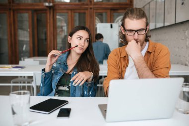 Toplantı salonunda oturuyor ve laptop ve cep telefonu ile masada çalışan genç öğrenciler portresi