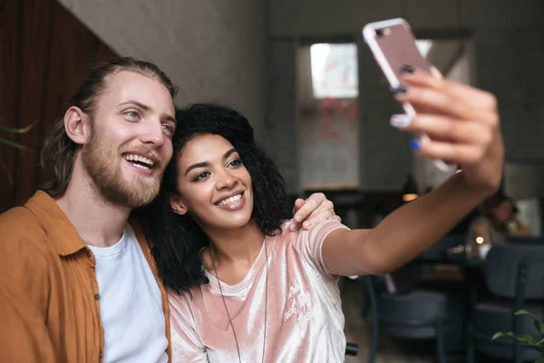 Mladý pár fotí na čelní mobilní telefon fotoaparát v restauraci. Pěkný africký americký lady takže foto s přítelem v kavárně — Stock fotografie