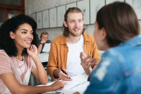 Jonge man en twee meisjes samen te werken in office. Groep studenten samen studeren in klas — Stockfoto