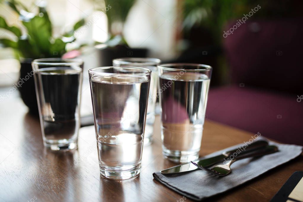 Close up photo of glasses with water on table in restaurant