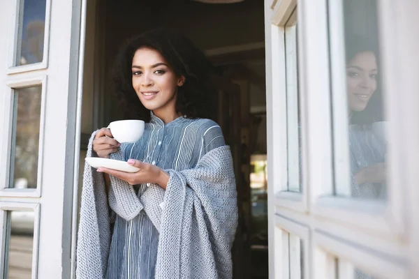 Ritratto di giovane ragazza afroamericana avvolta in plaid bere caffè nel ristorante — Foto Stock