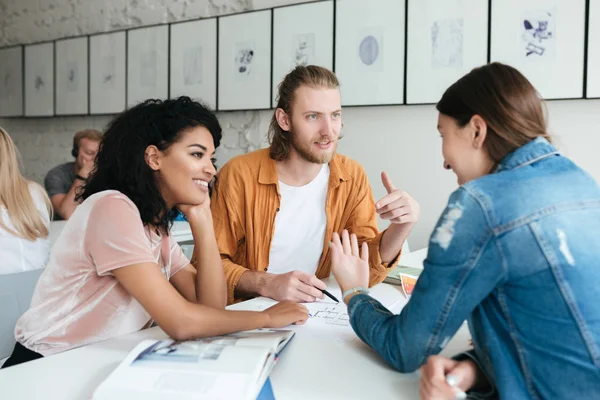 Jonge man en twee meisjes samen te werken in office. Groep studenten samen studeren in klas — Stockfoto