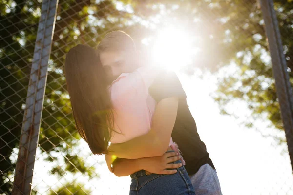 Schönes Foto von jungen nachdenklichen Jungen stehend und umarmt hübsches Mädchen, während sie Zeit im Park verbringen — Stockfoto