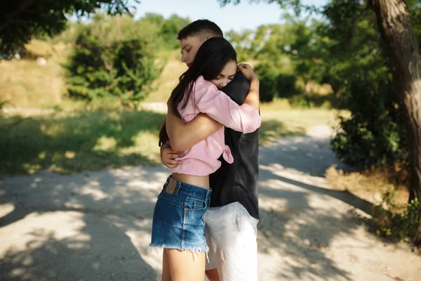 Bela foto do casal de pé e abraçando uns aos outros, enquanto cuidadosamente fechando os olhos no parque — Fotografia de Stock