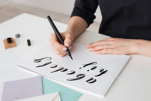 Retrato de manos de mujer joven escribiendo alfabeto sobre papel sobre escritorio aislado — Foto de Stock