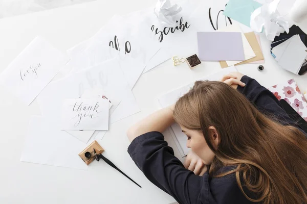 Foto van moe dame zit aan de witte Bureau en slapen met klassieke inkt pen en papier in de buurt van geïsoleerde — Stockfoto