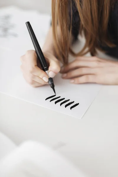 Cerca de la foto de las manos de la mujer sosteniendo la pluma y la escritura en papel aislado — Foto de Stock