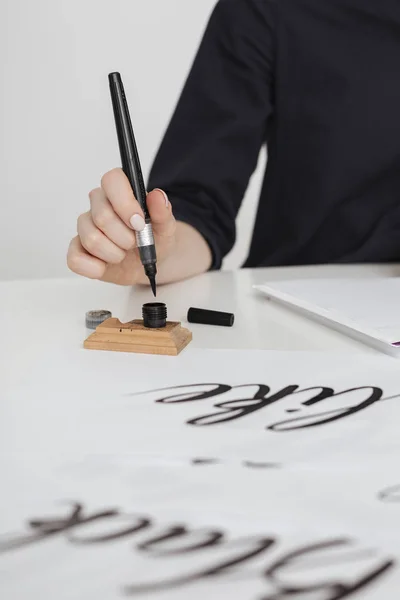Zdjęcie ręki młoda kobieta, pisanie na papierze na biurku na białym tle z bliska — Zdjęcie stockowe