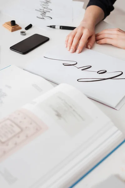 Feche a foto de mãos de mulher jovem com belas notas e livro aberto na mesa isolada — Fotografia de Stock