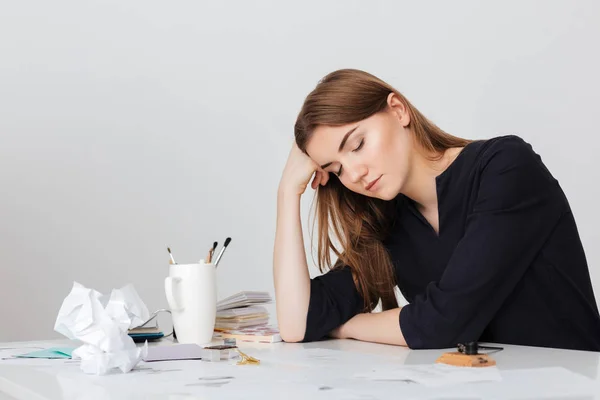 Foto av söt dam som sitter vid det vita skrivbordet och sover medan lutande huvud på hennes hand isolerade — Stockfoto