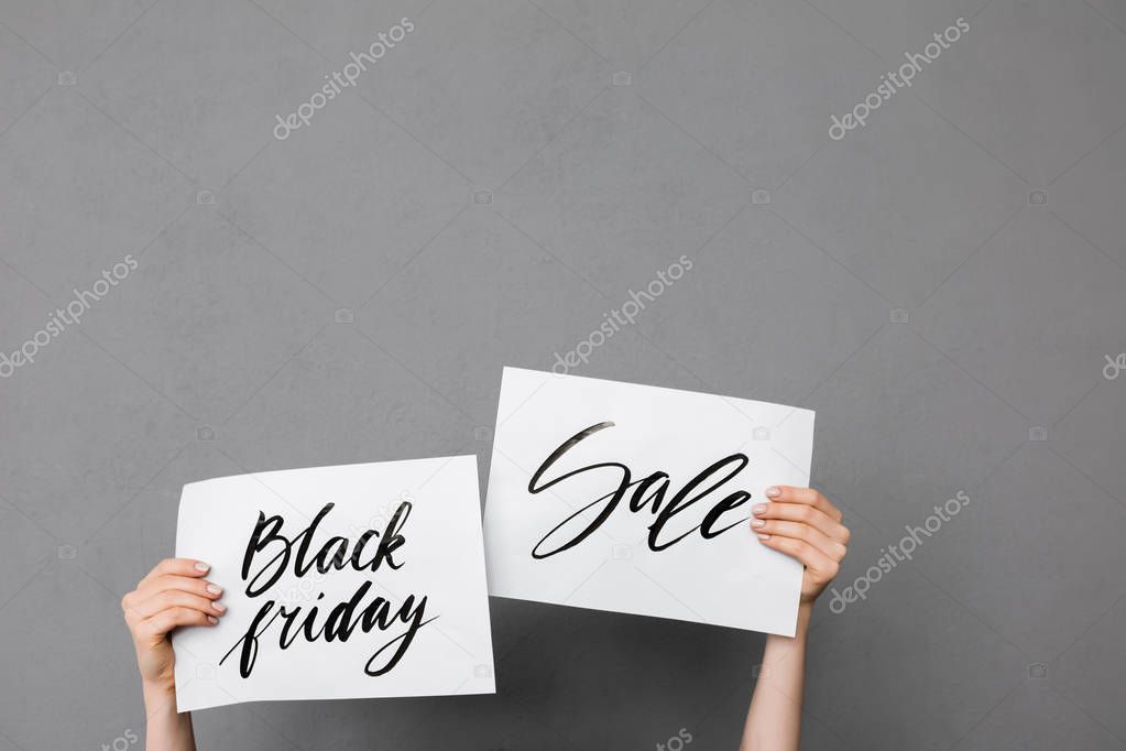 Close up photo of woman hands up that holding beautiful postcards on gray background